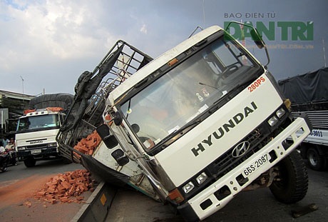 Xe tải chở gạch “dựa lưng” trên quốc lộ - 1 Chiếc xe tải đang sửa chửa, chuẩn bị cẩu đi thì gặp sự cố