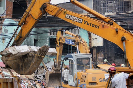 Hai xe cuốc thận trọng khi đào bới để tránh vào các nạn nhân. 