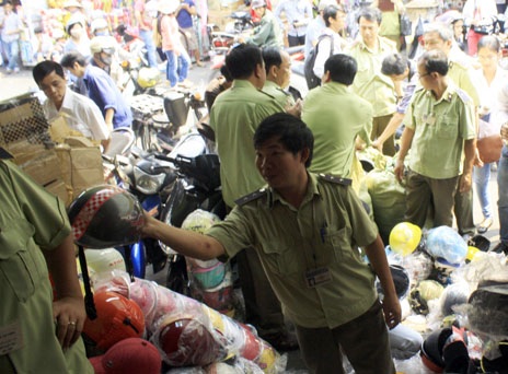 Phát hiện hàng trăm vụ hàng hóa “mất gốc” trên thị trường - 1 Lực lượng Quản lí thị trường kiểm tra một điểm kinh doanh mũ bảo hiểm tại chợ Kim Biên