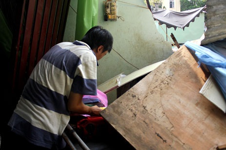Vụ căn nhà bị ủi sập: Một mảnh đất hai chủ? - 3 Anh Thiện đang moi một túi đựng giấy tờ từ đống đổ nát