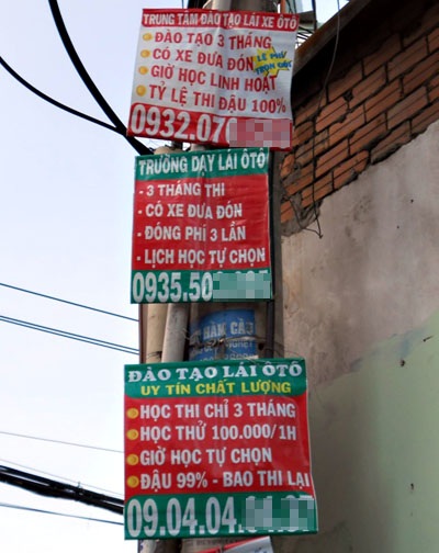 “Choáng” với quảng cáo đào tạo lái xe... đậu 99% - 2 3 tấm biển quảng cáo cùng nằm chung một cột điện