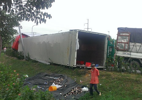Vào cua gấp, container chở bia lật chắn ngang đường - 2 Nhiều két bia bị vỡ vụn sau vụ lật xe