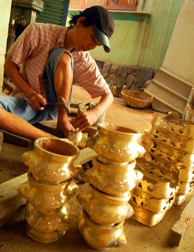 Một công nhân đang khắc hoa văn trên lư đồng