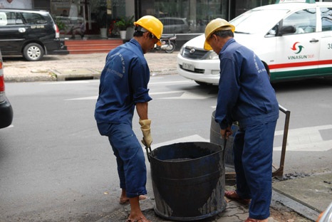 Một công nhân lọt thỏm trong lỗ cống, nơi chẳng ai muốn chui vào