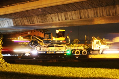 Xe quá khổ lại “đội” cầu vượt - 1 Chiếc xe đầu kéo chở theo xe cuốc dính chặt dưới gầm cầu vượt Quang Trung