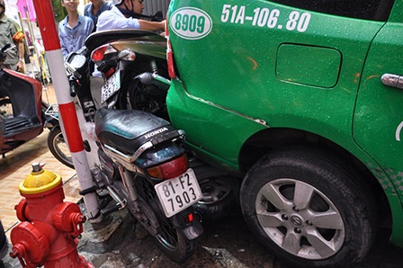 Chiếc taxi chạy lùi tông vào 2 ô tô và nhiều xe máy