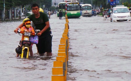 Kiếm tiền triệu mỗi ngày nhờ... ngập lụt - 1 Một thợ sửa xe trên đường Kinh Dương Vương tiếp cận, hỗ trợ người đi đường bị chết máy