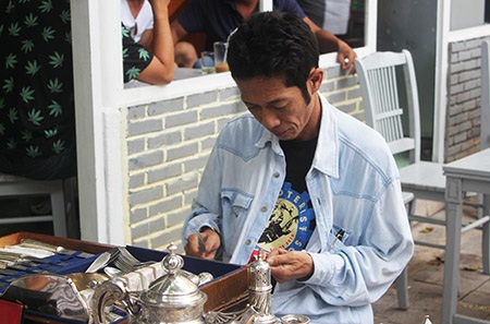 Chủ một sạp hàng đang lai chùi những món đồ của mình