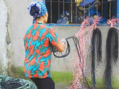Người phụ nữ ở xóm lao động nghèo đang tiến hành xẻ thịt dây điện lấy lõi đồng
