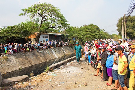 Người dân hiếu kỳ đứng hai bên bờ kênh 19/5 dõi theo vụ việc