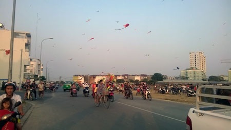 Vướng vào dây diều, một người nguy kịch - 3 Hàng trăm người dân tập trung thả diều gần đường dây điện cao áp và nơi đông người chạy xe qua lại