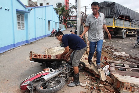 Xe khách lùi húc đổ 20m tường, 8 người thoát nạn - 2 Xe máy bị mảng tường sập đè lên