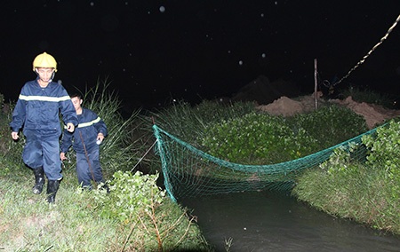 Mảnh lưới được thả xuống đón đầu một dòng chảy đổ ra từ cống thoát nước