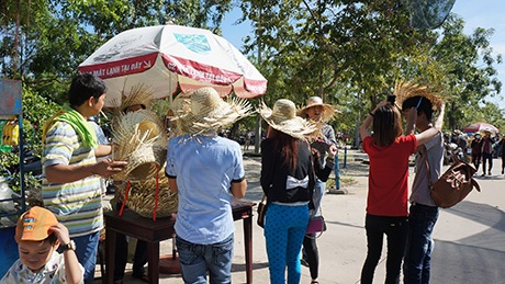 Hàng vạn người đổ về KDL Đại Nam trong ngày “xả cửa” - 6 Du khách mua nón lá để chống lại nắng nóng