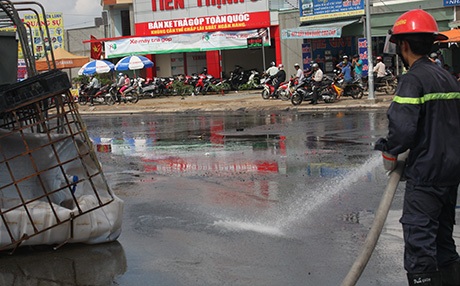 Xe tải lật, hàng ngàn lít axit tràn đường, bốc hơi nghi ngút - 6 Lính cứu hỏa dùng vòi rồng xịt nước rửa axit dưới mặt đường