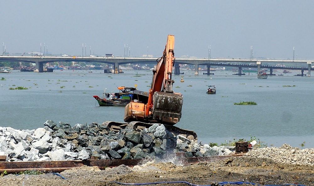 Xà lan chở đá và máy cuốc đẩy đá xuống lấp sông