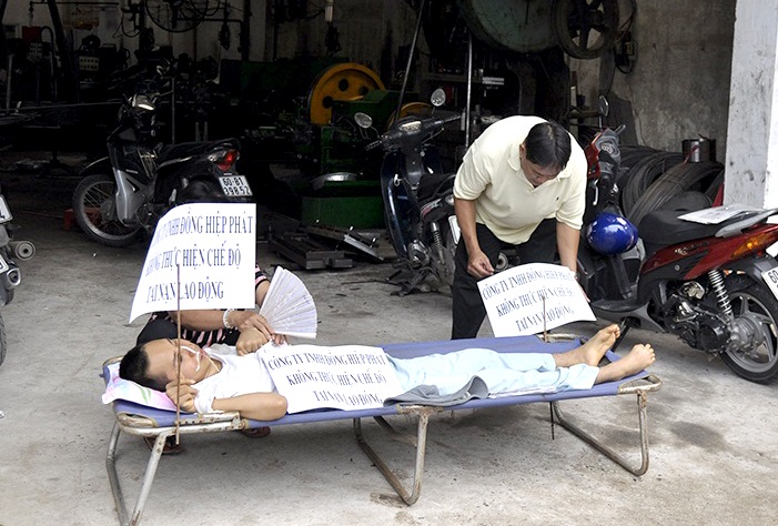 Anh Vũ Ngọc Dũng được đặt trên băng ca, nằm trước cổng Công ty TNHH Cơ khí chính xác Đồng Hiệp Phát