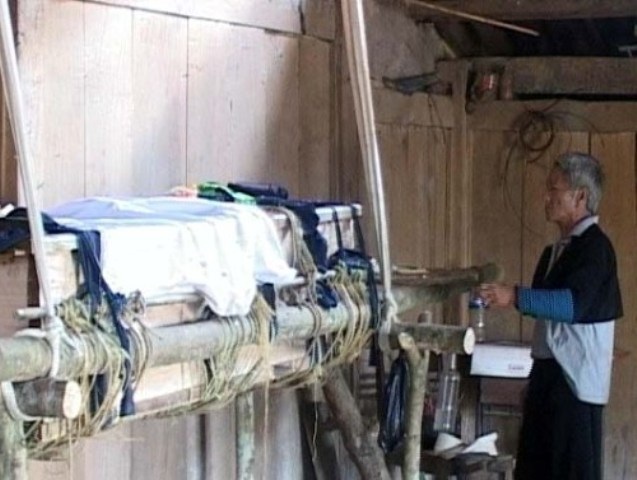 Chiếc quan tài đang dần được đưa vào trong tục mai táng người chết của đồng bào H'Mông