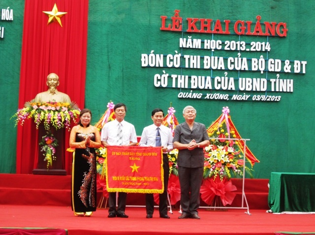 UBND tỉnh Thanh Hóa trao tặng cờ thi đua cho Trường THPT Quảng Xương I. (Ảnh: Nguyễn Thùy)