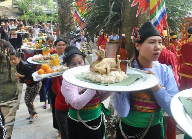 Những phụ nữ mặc áo truyền thống mang lễ vật dâng thần cá