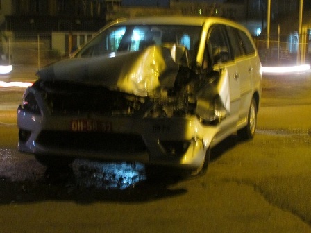 Chiếc xe ô tô 7 chỗ sau khi tông xe khách bị hư hỏng nặng, nằm quay ngang đường