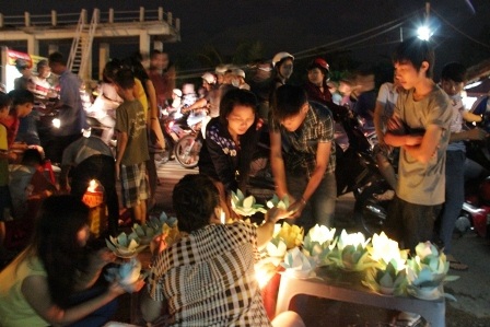 Rất đông bạn trẻ mua đèn hoa đăng thả xuống sông để cầu sự bình an, hạnh phúc