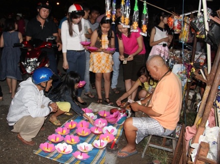 Rất đông bạn trẻ mua đèn hoa đăng thả xuống sông để cầu sự bình an, hạnh phúc