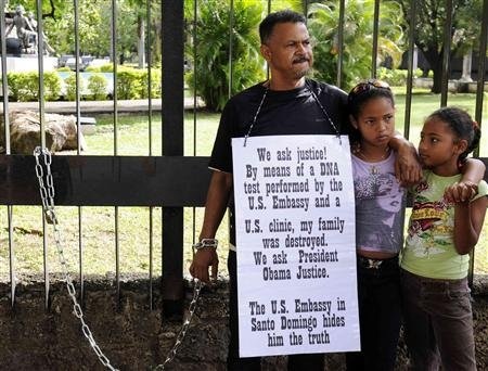 Người đàn ông tự xích mình trước cửa lãnh sự quán Mỹ  - 1 Miguel Familia tự xích tay mình ở hàng rào sứ quán Mỹ tại Cộng hòa Dominica.