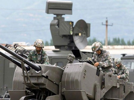 Các binh sỹ nạp đạn cho súng phòng không 2 nòng PG99 35mm trước một xe radar điều khiển hỏa lực