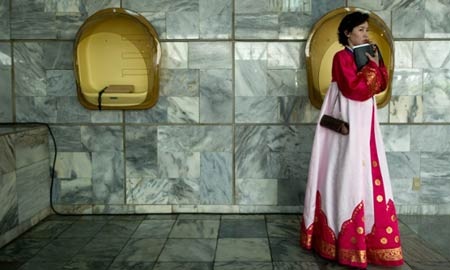 Binh sỹ Triều Tiên đứng dưới một biển quảng cáo lớn ở gần một sân bay tại Bình Nhưỡng.