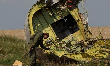 Bí ẩn buồng lái MH17 bị cưa đôi - 1 Một binh sỹ nổi dậy xem xét một mảnh vỡ của Mh17.