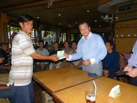 12 ngư dân Việt bị bắt ở Philippines đã về nước - 1 Đại sứ Việt Nam tại Philippines Trương Triều Dương trao giấy thông hành cho các ngư dân để về nước.