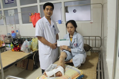 Cô gái mắc bệnh chân voi đã trải qua đợt phẫu thuật đầu tiên - 1 Bác sỹ Chu Văn Chiến trao quà bạn đọc báo Dân trí tới em Nguyễn Thị Trưng