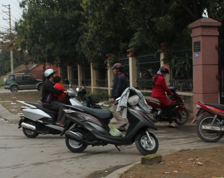 Sau nghỉ Tết, phụ huynh “quên” đội mũ bảo hiểm cho con - 5 Không đội MBH còn ngồi vắt vẻo trên người mẹ.