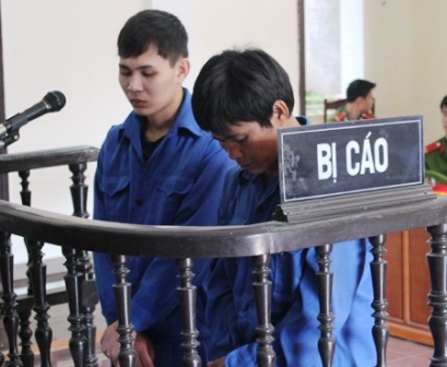 Giết hàng xóm, hai cha con cùng lĩnh án tù - 1 Nguyễn Đình Long (bên trái) và con trai Nguyễn Đình Cường trước vành móng ngựa