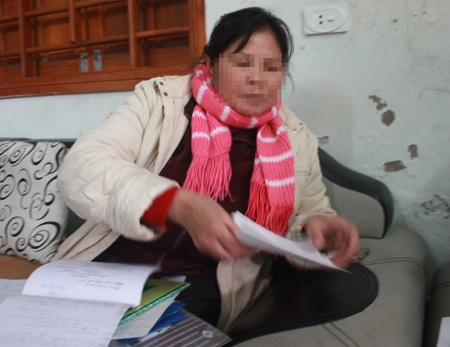 Bán nhà trả nợ vì môi giới xuất khẩu lao động - 1 Bà T.T.D cùng với những tờ giấy biên nhận viết tay của đại diện Công ty TNHH Đ.P.
