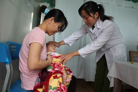 Tết của những đứa trẻ sinh ra trong trại giam - 1 Cán bộ Trạm xã Trại tạm giam Công an tỉnh Nghệ An kiểm tra sức khỏe cho cháu bé được sinh ra ở tù.