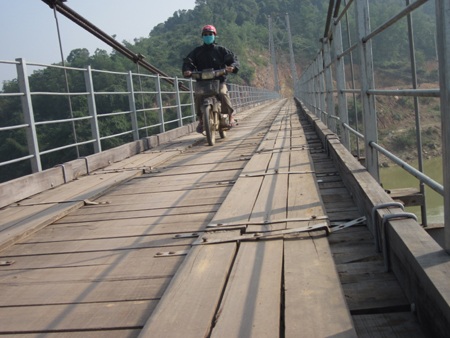 Cầu treo “lỏng lẻo” vì thiếu kinh phí! - 4 Ván gỗ mặt cầu bị mục nát, bu lông lan can cầu Đò Rô bị mất.