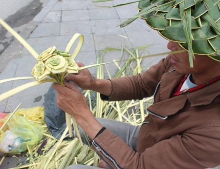 Anh Thắng đang hoàn thiện một bó hoa hồng lá dừa nước non. Mỗi bó có giá từ 50-70 nghìn đồng.