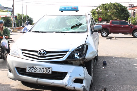 Phần kính chắn gió của xe taxi bị vỡ sau khi chiếc xe hất người điều khiển xe máy lên nắp capo.