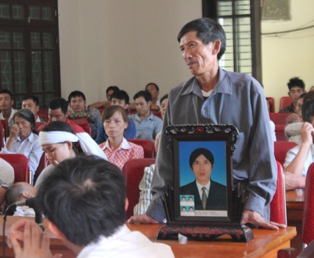 Thân nhân bị hại mang di ảnh Nguyễn Hoàng Thông tới tham dự phiên tòa.