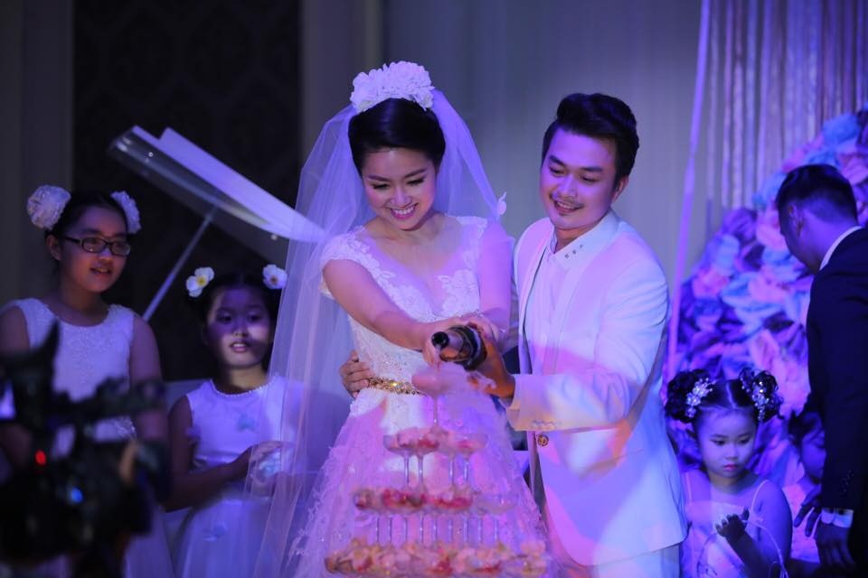 Tiệc cưới ngọt ngào của "cô dâu đại chiến" Lê Khánh - 7 Chú rể cầm tay cô dâu rót rượu sâm banh mừng ngày vui.