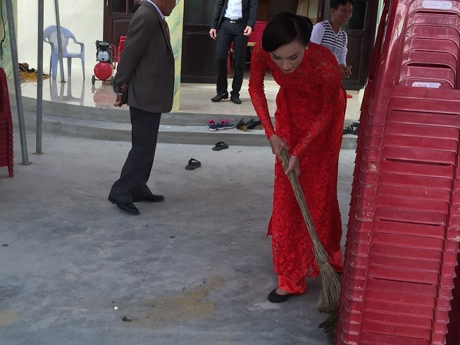 Chú rể Đỗ Khải An phụ giúp chỉnh trang lại bàn thờ tổ tiên trước khi bắt đầu buổi lễ.