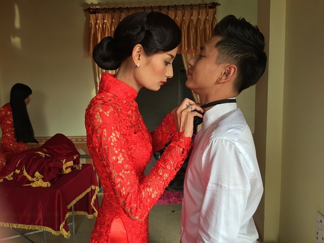 Cặp đôi tình cảm chỉnh sửa trang phục cho nhau trước khi nghi thức của lễ ăn hỏi diễn ra.