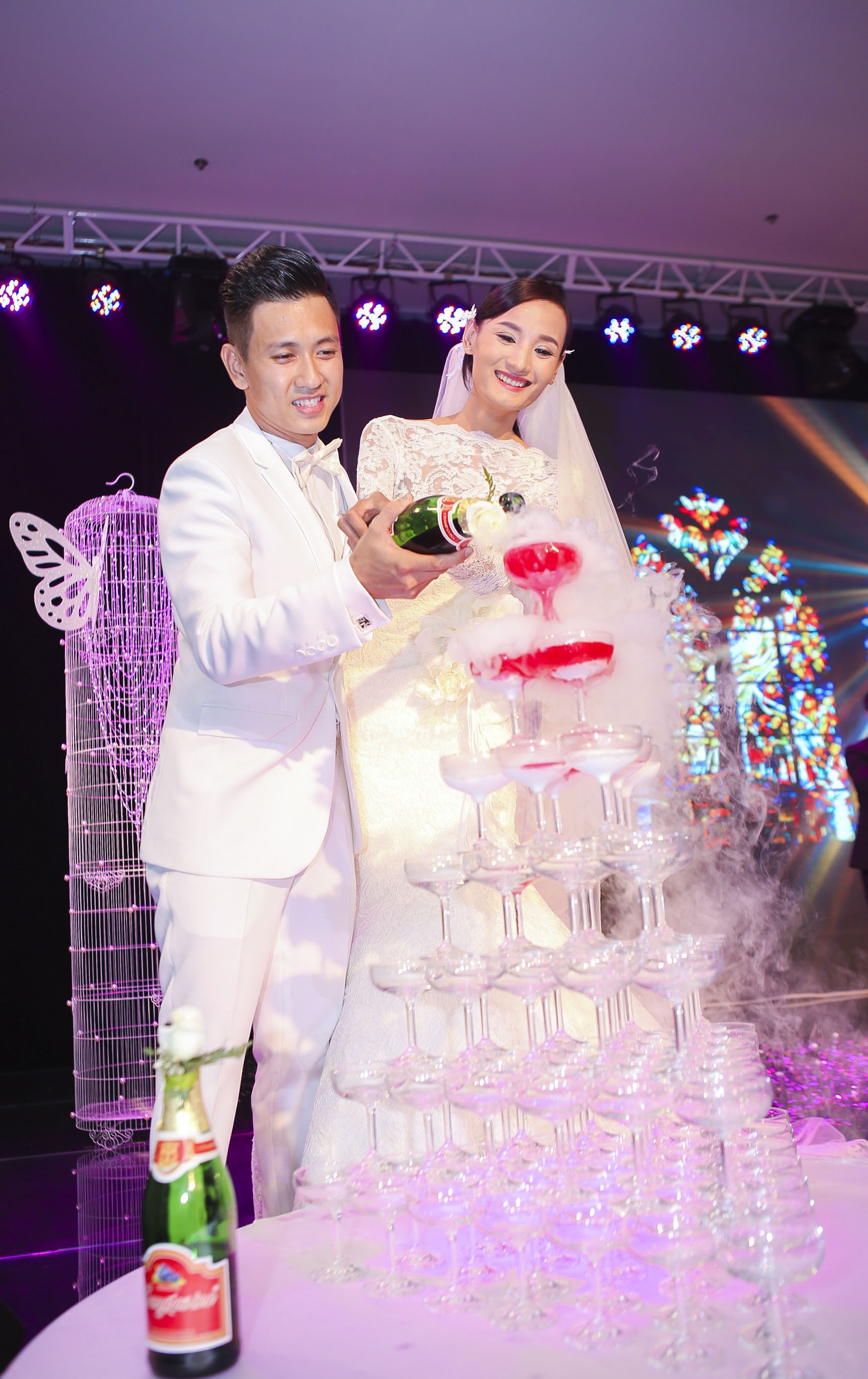 Cô dâu chú rể cầm tay nhau rót rượu mừng trong tiếng vỗ tay của mọi người.