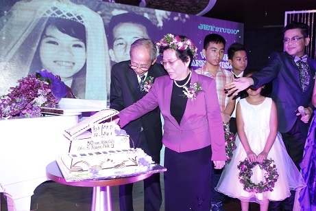 Cặp đôi 50 năm cùng nhau nắm tay cắt bánh kỷ niệm trong tiếng vỗ tay chúc mừng của mọi người.