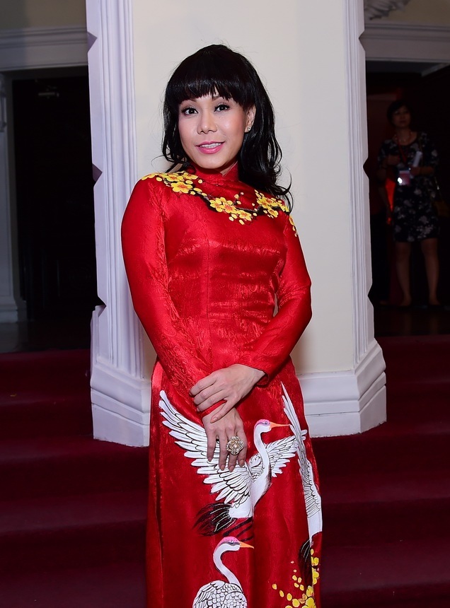 Nghệ sĩ Việt Hương diện áo dài đỏ với họa tiết hoa mai vàng đậm chất tết.