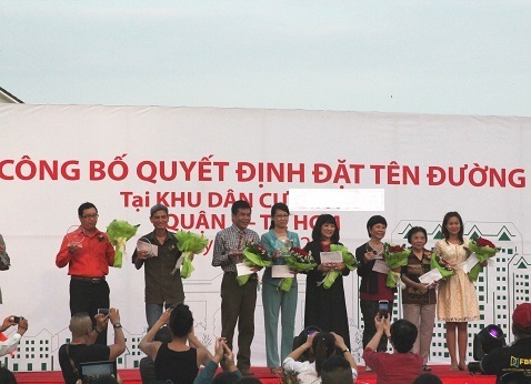 Đại diện gia đình của 8 cố văn nghệ sĩ được đặt tên đường lên nhận kỷ niệm chương từ UBND Q.9