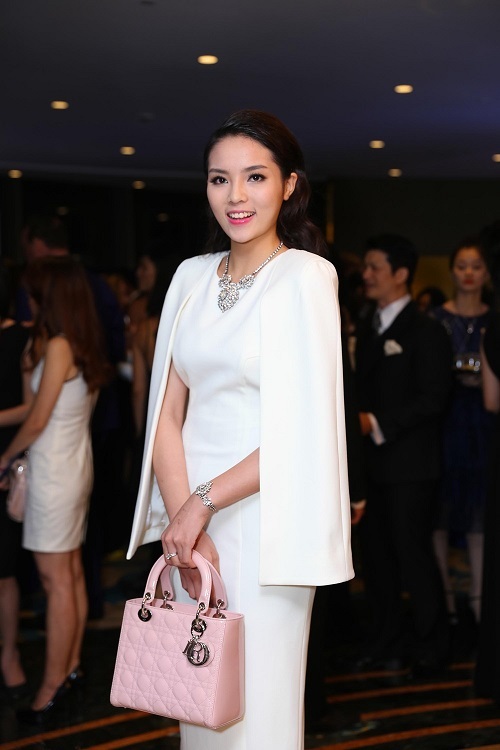 Kỳ Duyên chọn chiếc túi màu hồng nhạt đi kèm với bộ váy trắng kín đáo.