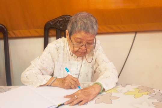 Cụ bà năm nay đã 90 nhưng bà vẫn tự tay mình ghi sổ tang bằng bàn tay run run. 